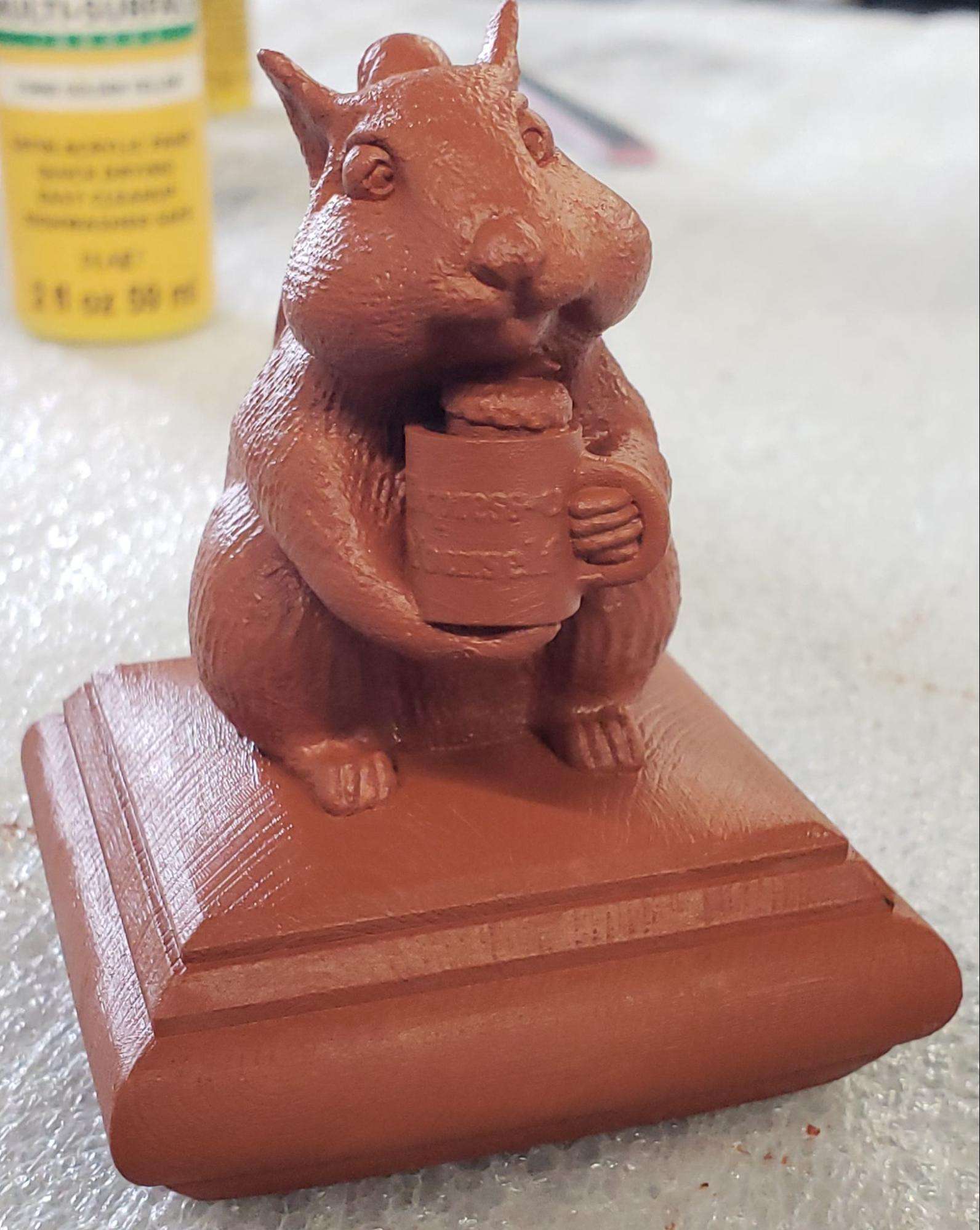 3D Printed squirrel cap being painted in brown wood