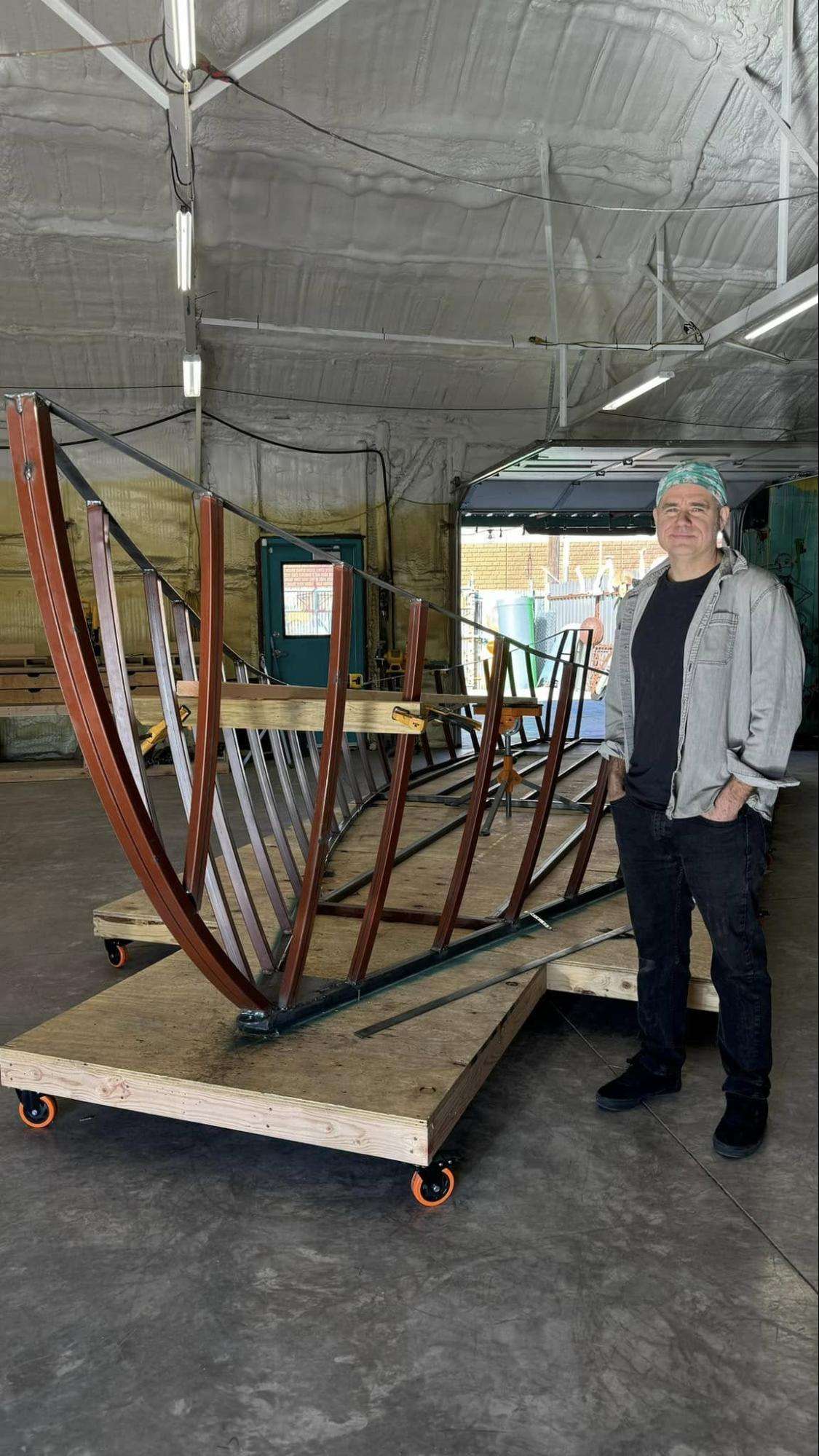 Gabriel Friedman standing next to the frame Vietnamese Refugee Boat