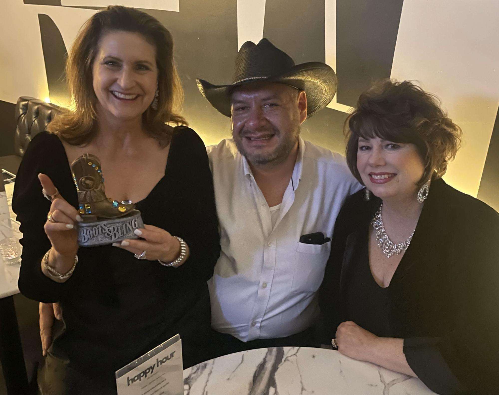 Birthday lady holding her Boots & Bling gift in a photo op